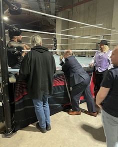 several people in a boxing ring talking to each other