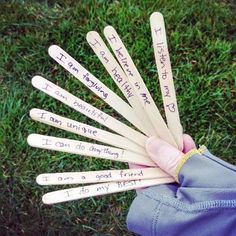 a person holding several wooden sticks with writing on them