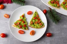 two slices of toast with guacamole and tomatoes