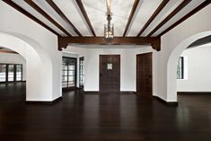 an empty room with wood floors and beams on the ceiling is seen in this image