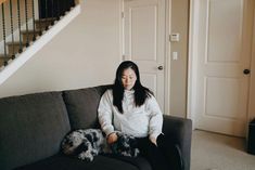 a woman sitting on a couch with her dog