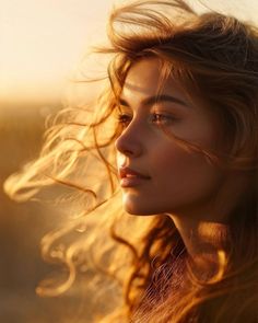 a beautiful young woman with long hair blowing in the wind, looking off into the distance