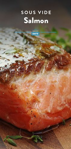 salmon fillets on a cutting board with herbs and seasoning in the background text says sous vide salmon