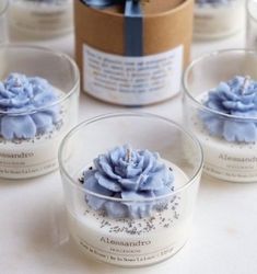 several small glass bowls with blue flowers in them and a box behind them that has a bow on it