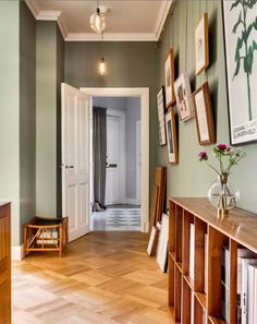 a hallway with wooden floors and pictures on the wall