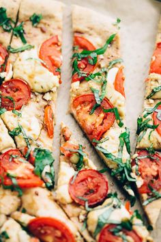 several slices of pizza with tomatoes and basil on them