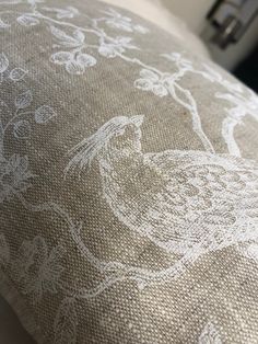 a close up of a pillow with a bird on it