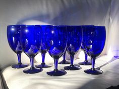 six blue wine glasses lined up on a table