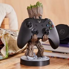 a statue of groote holding a video game controller on top of a table