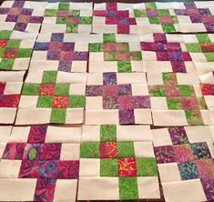 a quilted table top with squares and flowers on it