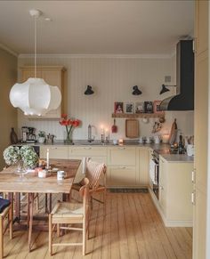 an open kitchen and dining room with wooden floors, white walls and cabinets is featured on the instagram page