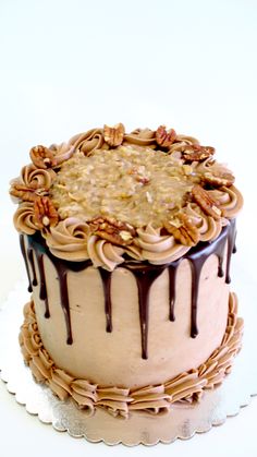 a cake with chocolate frosting and pecans on top