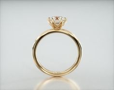 a yellow gold engagement ring with a single diamond