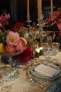 the table is set with flowers and candles