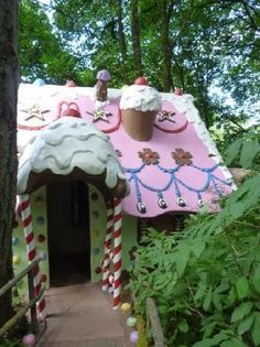 a pink and white gingerbread house in the woods