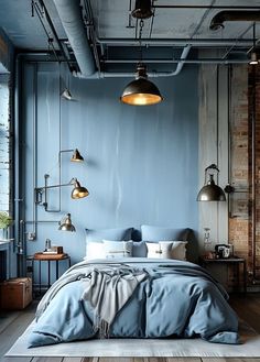 an industrial bedroom with blue walls and wooden flooring is furnished with metal lighting fixtures