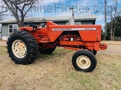 an orange tractor parked in front of a house