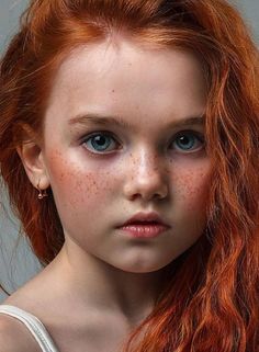 a red haired girl with freckles on her face and hair is looking at the camera