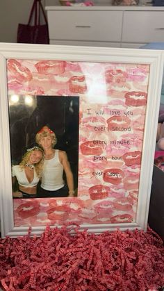 two women are posing in front of a picture frame with pink candy on the ground