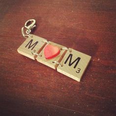 a wooden keychain with a red heart on it and the word mm spelled out