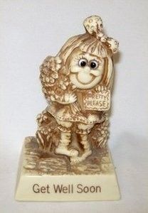 a ceramic figurine of a girl holding a sign that says get well soon