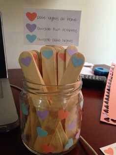 a jar filled with wooden sticks sitting on top of a desk