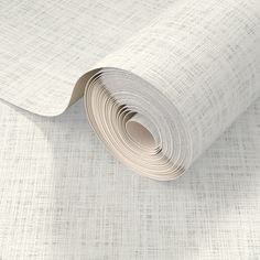 a roll of white paper on top of a wallpaper covered in light grey fabric