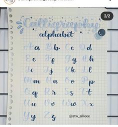 an open notebook with writing on it and the words calligraphy alphabet written in blue ink