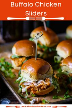 small sandwiches with toothpicks stuck in them sitting on a tray next to other food items