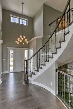 a staircase leading up to the second floor in a house with gray walls and wood floors