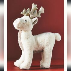 a white stuffed animal with a gold star on it's head, standing in front of a red background