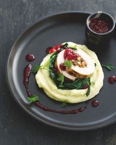 a black plate topped with food and garnish