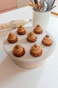 a white plate topped with cupcakes on top of a table next to utensils