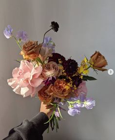 a person holding a bouquet of flowers in their hand