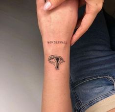 a woman's arm with a tattoo on it that reads wonderwall and an elephant