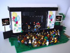 a group of people standing on top of a lego stage