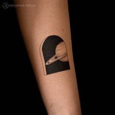 a tattoo on the arm of a person with an image of saturn and its moon