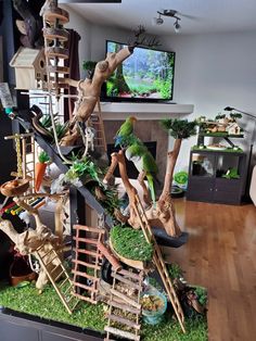 a bird perched on top of a tree filled with furniture and treestand in front of a flat screen tv