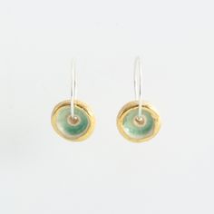 A gorgeous pair of small ceramic hoop earrings in rich sea-coloured green glass and gold detailing. Stylish and delicately designed, these sterling silver hoops are light and comfortable to wear. Made from ceramic, glass, real gold detailing and sterling silver hoops. Timeless and sophisticated handcrafted women's jewellery. Each piece has been carefully hand-shaped and painted, adding an elegant and contemporary feel. The kiln-fired glass gives the piece a high quality and gemstone-like appearance. The luxurious smoothness of the pooled glass gives a soothing sensory experience - similar to that of a comforting touchstone you would keep in your pocket. It's hard to describe, but we just can't stop feeling the surface with our fingers! As each individual piece is handmade, each one is comp Green Small Hoop Earrings For Everyday, Green Small Hoop Sterling Silver Jewelry, Green Sterling Silver Small Hoop Jewelry, Green Sterling Silver Small Hoop Earrings, Stop Feeling, Sea Colour, Sensory Experience, Sterling Silver Hoops, It's Hard