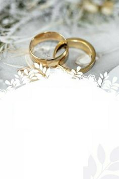 two gold wedding rings sitting next to each other on a lace covered tablecloth with white flowers