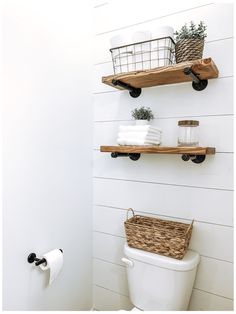 a white toilet sitting next to a wooden shelf