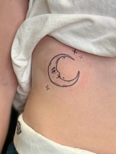 a woman's stomach with a crescent tattoo on it