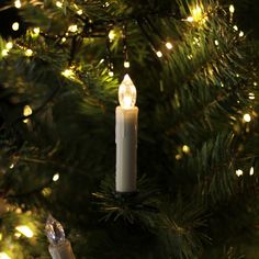 a lit candle hanging from a christmas tree