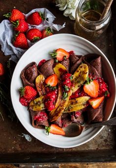 a white bowl filled with fruit on top of a table