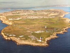 an aerial view of the coast and lighthouses in the ocean with land around it