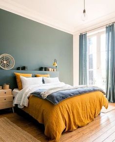 a bedroom with blue walls and yellow bedding