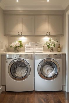 a washer and dryer in a room with wooden floors, cabinets and drawers