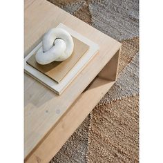 a wooden table topped with a white doughnut on top of a piece of wood