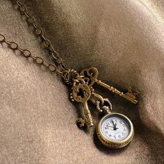 "Steampunk style pocket watch and antique skeleton keys dangle from this Victorian necklace. Real working clock with a cool vintage vibe. Burnished bronze metal finish. This necklace is finished by a lobster claw clasp. Size: 29\" long Made in our Los Angeles, CA studio. Contact us for bulk pricing and wholesale information." Alice In Wonderland Key, Clock Necklace, Watch Pendant, Steampunk Watch, Victorian Necklace, Pocket Watch Necklace, Skeleton Keys