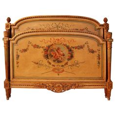 an ornately decorated bed frame with flowers and cherubs on the headboard